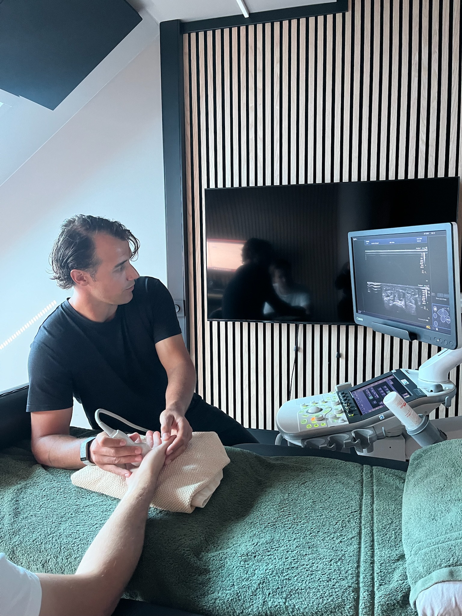 Osteopat Stian Lauritzen undersøker en pasient med ultralyd ved Helseblikk i Grimstad